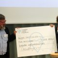 Kenneth M Persson lämnar över checken på 3 miljoner SEK till Lunds universitets Stacey Sörensen