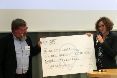 Kenneth M Persson lämnar över checken på 3 miljoner SEK till Lunds universitets Stacey Sörensen